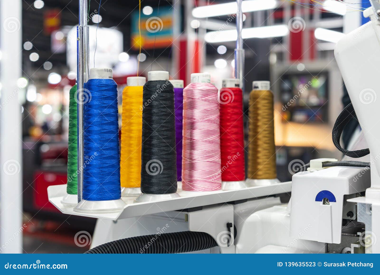 many colorful cotton reel thread set up at modern and automatic high technology sewing or embroidery machine for textile Ã¢â¬â